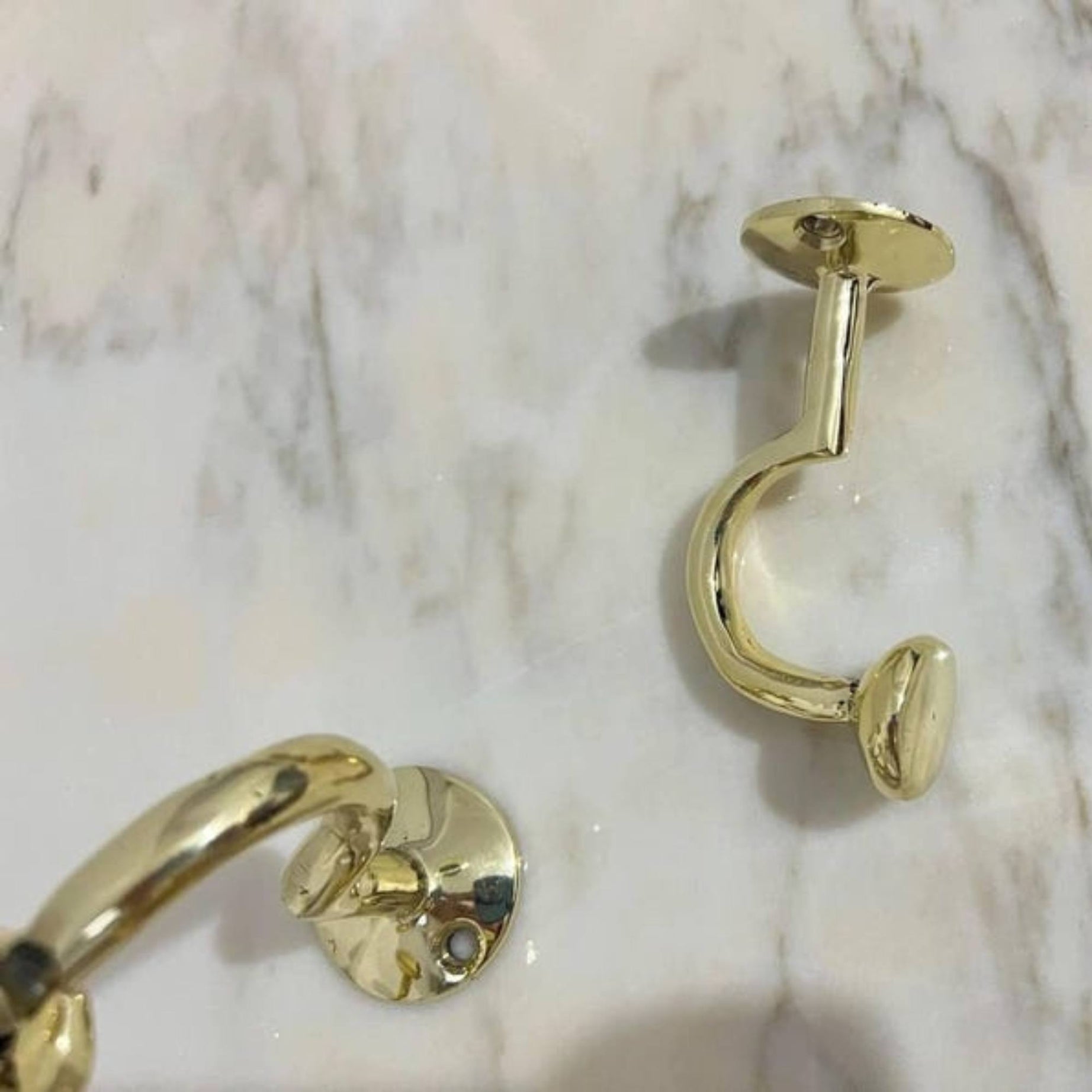 Gold hooks earrings on a marble surface