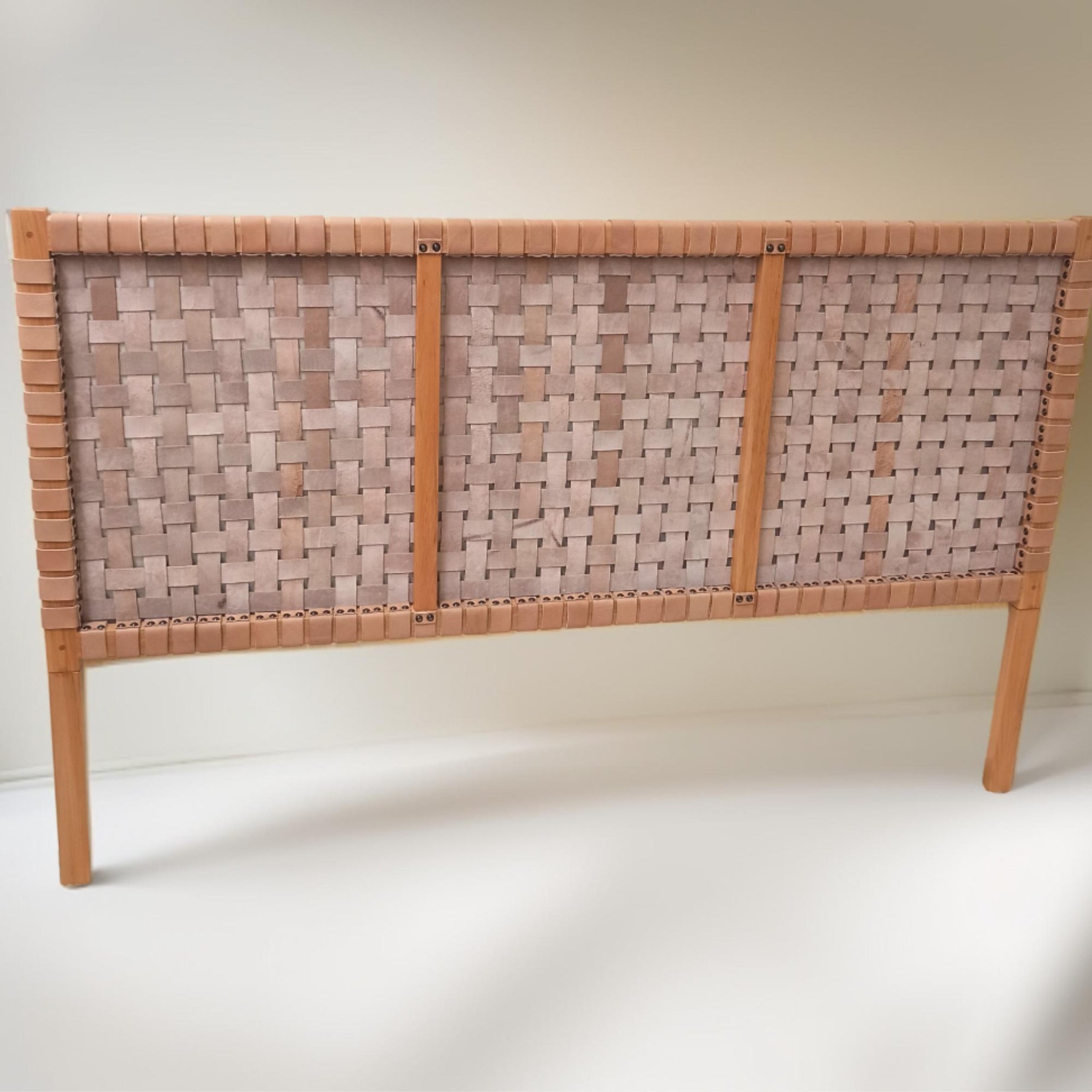 back view Contemporary strap woven leather king headboard showcased in a trendy, modern bedroom.
